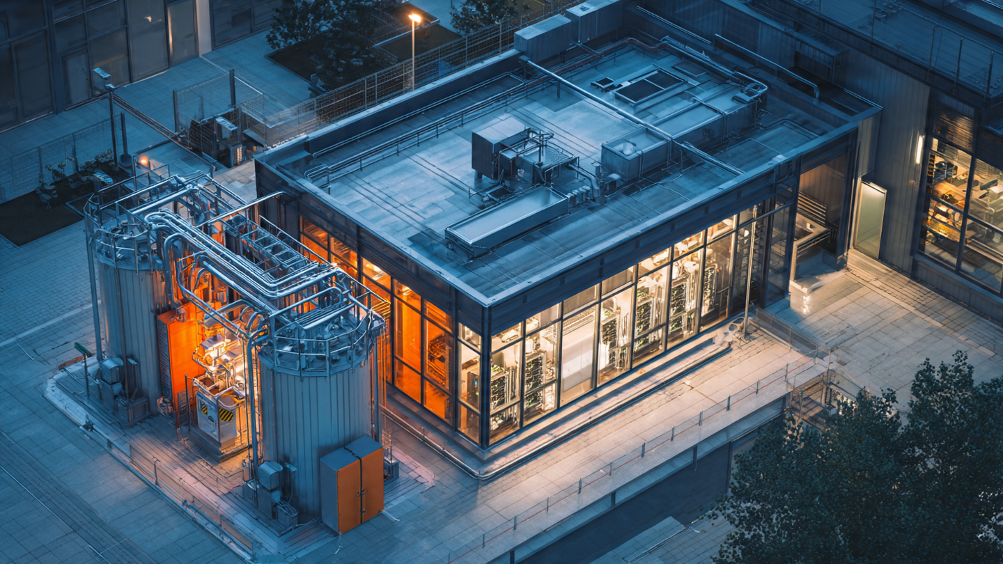 A compact microreactor installation adjacent to a modern data center facility at dusk